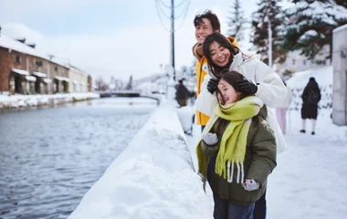 Family looking across the river in snowy town.