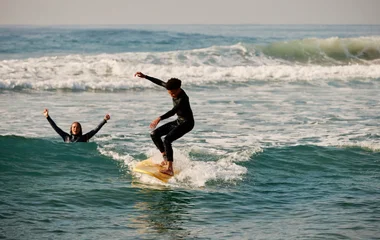 Dos personas practicando surf.