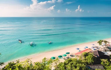 A beach with turquoise water and palm trees