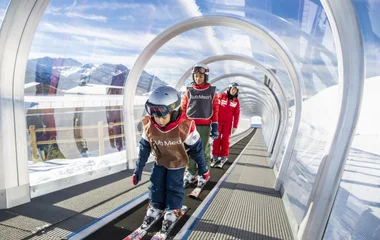enfants sur le magic carpet apprenant à skier